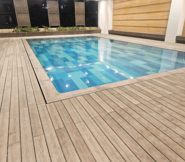 Swimming pool with stylish WPC decking for durable outdoor flooring.
