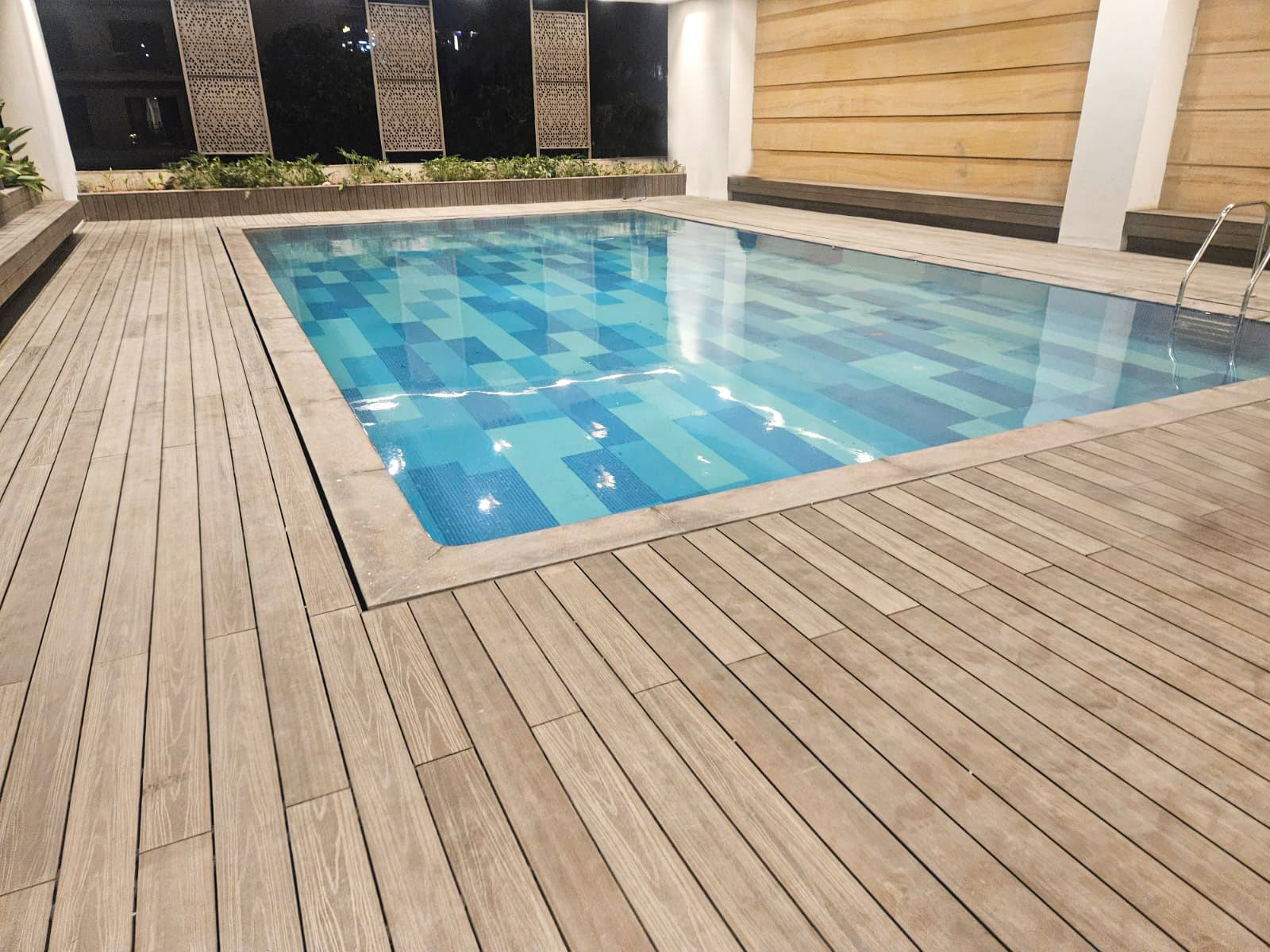 Swimming pool with stylish WPC decking for durable outdoor flooring.